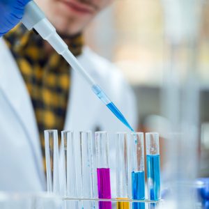 Portrait of concentrated scientist making experiment in laboratory.